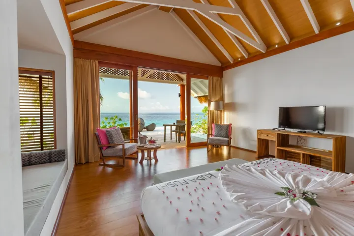 Kudafushi Resort & Spa, Мальдивы — интерьер виллы Kudafushi Resort & Spa — просторная спальня пляжной виллы с деревянной отделкой