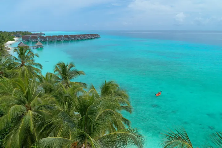 Kuramathi Maldives — человек в каяке в бирюзовых водах лагуны