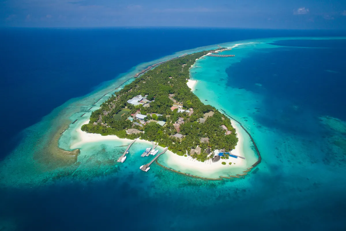 Kuramathi Maldives — вид на вытянутый зеленый остров с высоты