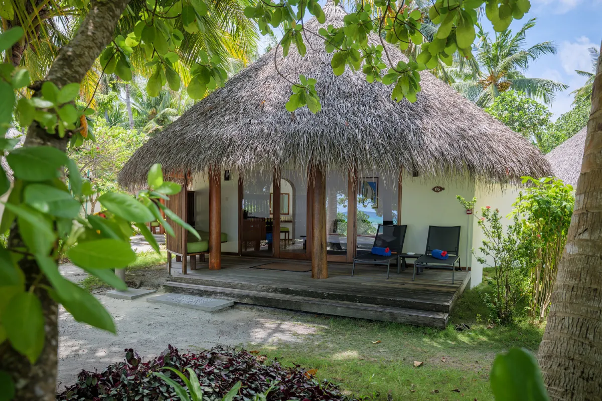 Kuramathi Maldives — пляжная вилла с соломенной крышей в тропическом саду