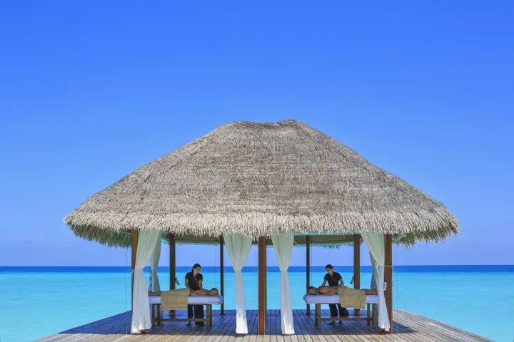Kuramathi Maldives — открытый массажный павильон над бирюзовой лагуной