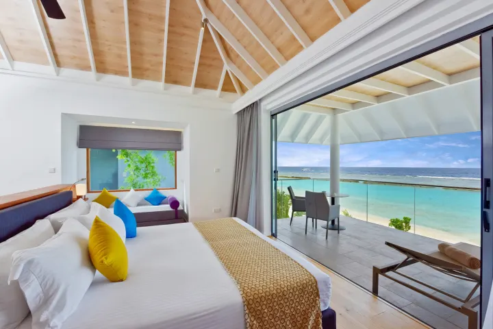 Kuramathi Maldives — светлая спальня с выходом на открытую террасу