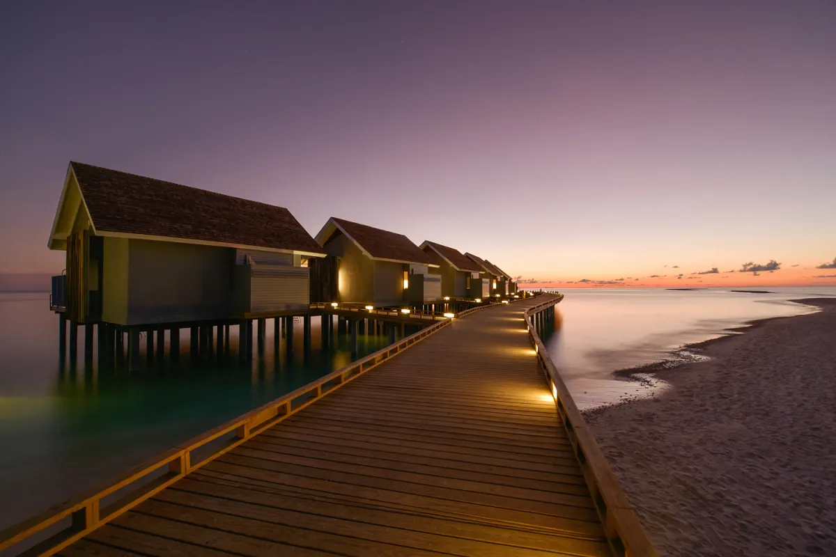 Kuramathi Maldives — водные виллы на сваях над океаном на закате