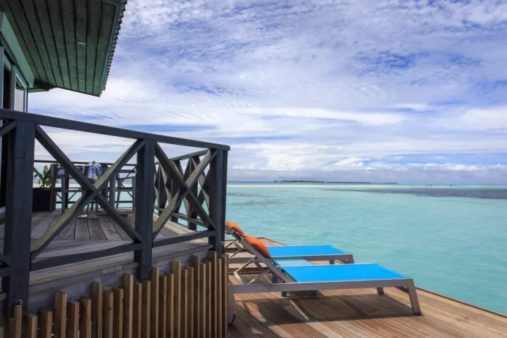 Kuredu Island Resort & Spa, Мальдивы — вилла на воде Kuredu Island Resort & Spa — терраса водной виллы с шезлонгами и видом на океан