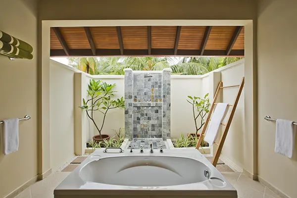 Kurumba Maldives — открытая ванная комната с ванной и тропическим душем