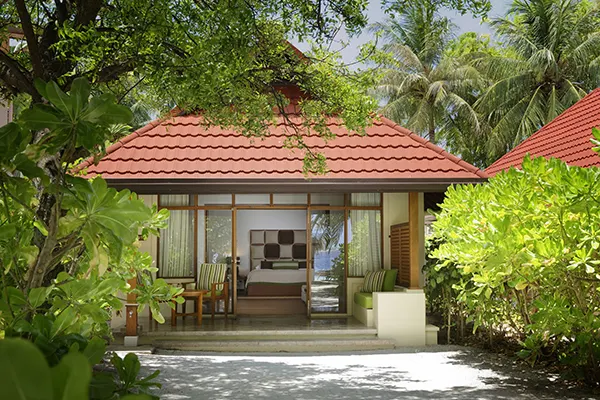 Kurumba Maldives — вилла с красной крышей среди тропической зелени