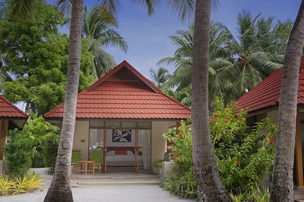 Kurumba Maldives — бунгало с деревянной террасой в окружении пальм