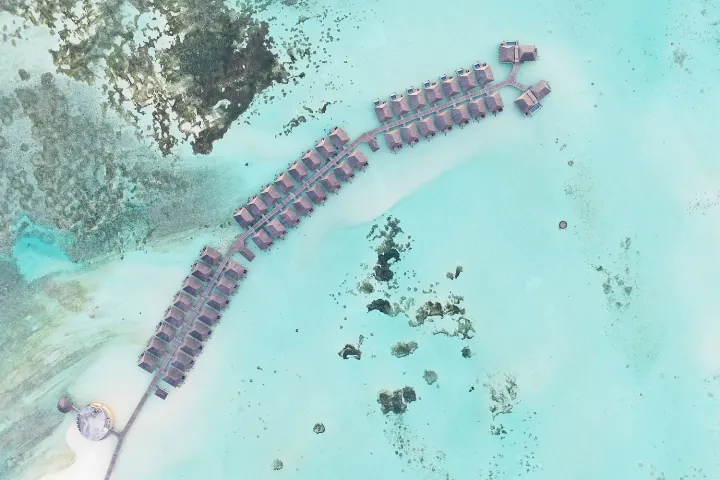 Le Meridien Maldives Resort & Spa — вид с воздуха на цепочку водных вилл в лагуне атолла Лавияни
