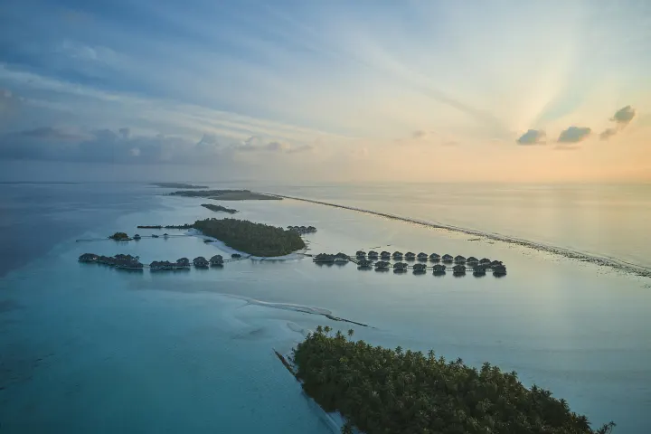 Maalifushi by COMO — вид сверху на острова с водными виллами на закате