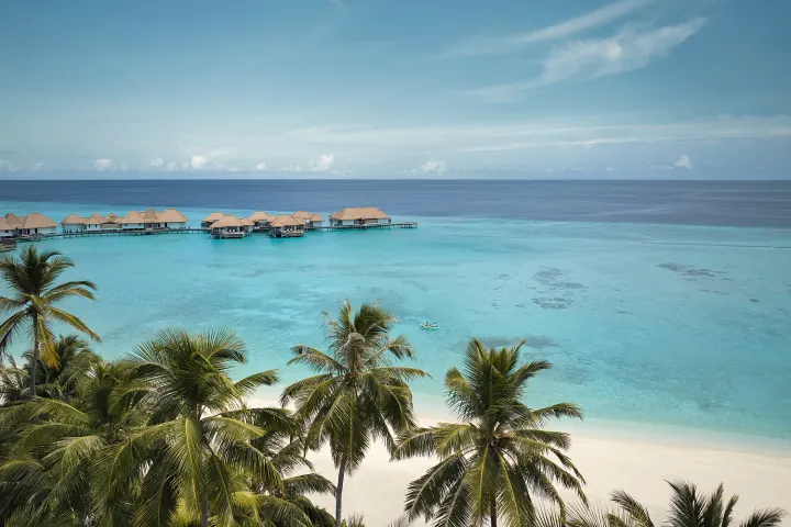 Maalifushi by COMO — вид с воздуха на ряд водных вилл и лагуну