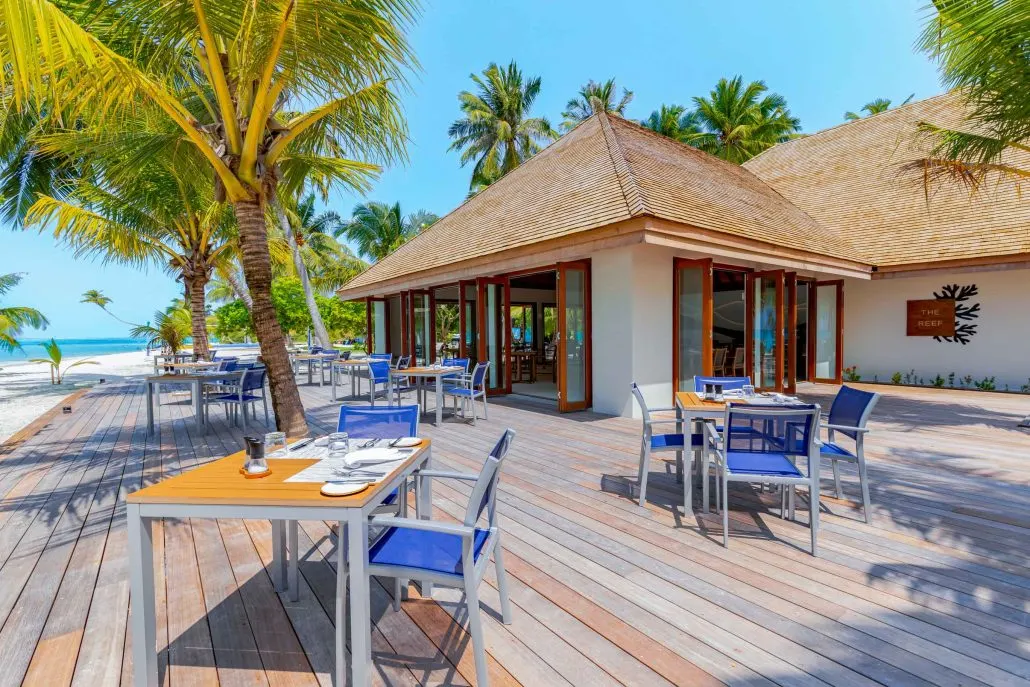 Meeru Island Resort & Spa — столики ресторана на открытой деревянной террасе