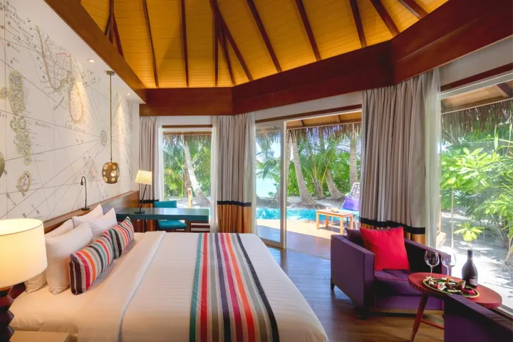 Mercure Maldives Kooddoo, Мальдивы — интерьер виллы Mercure Maldives Kooddoo — светлая спальня с яркими подушками и ковром