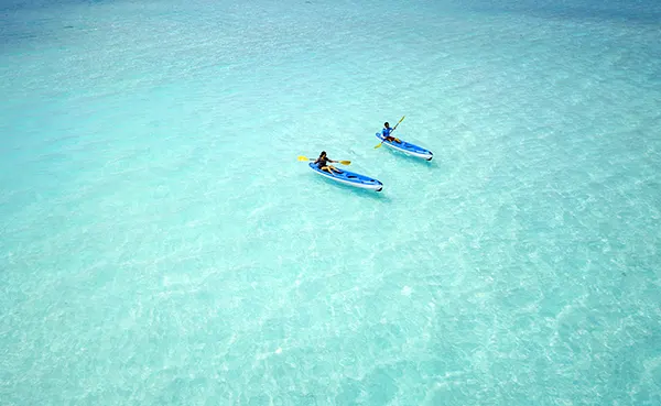 Milaidhoo Island Maldives — гости катаются на каяках по бирюзовой воде