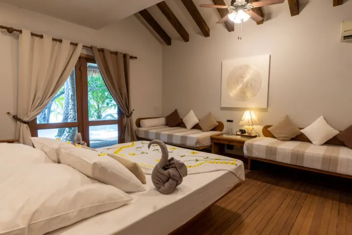 NAKAI Alimatha Resort — уютная спальня пляжного бунгало с выходом на террасу
