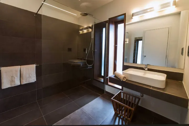 NAKAI Dhiggiri Resort — интерьер водного бунгало с деревянной отделкой и панорамным видом на лагуну