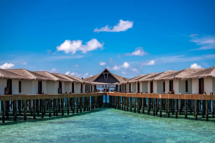 NAKAI Dhiggiri Resort — водные бунгало на сваях над прозрачной бирюзовой водой лагуны