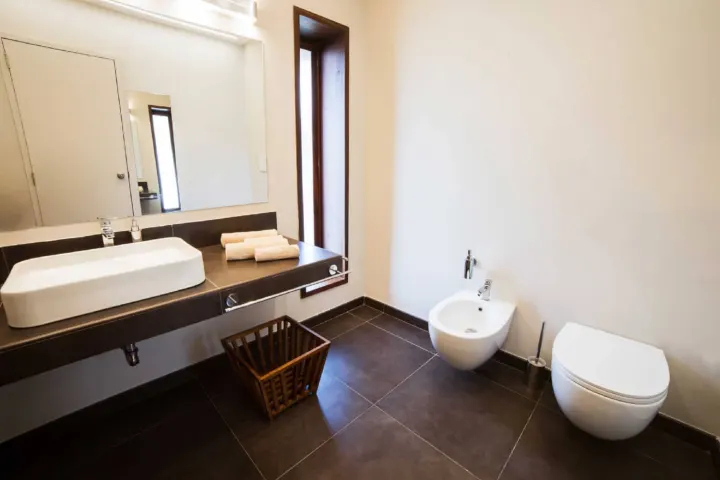NAKAI Dhiggiri Resort — деревянная терраса водной виллы с шезлонгами и прямым спуском в океан