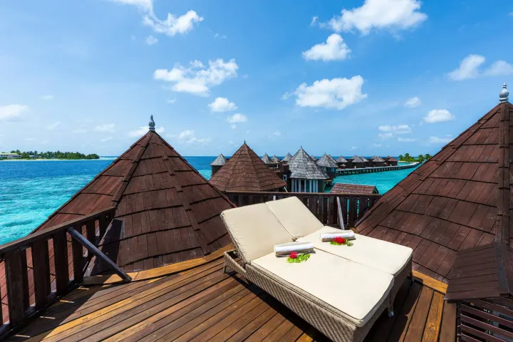 Nika Island Resort & Spa — интерьер водной виллы с отделкой из натурального дерева
