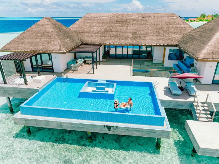 NOOE Maldives Kunaavashi — круговой инфинити-бассейн и бар у пляжа с видом на лагуну