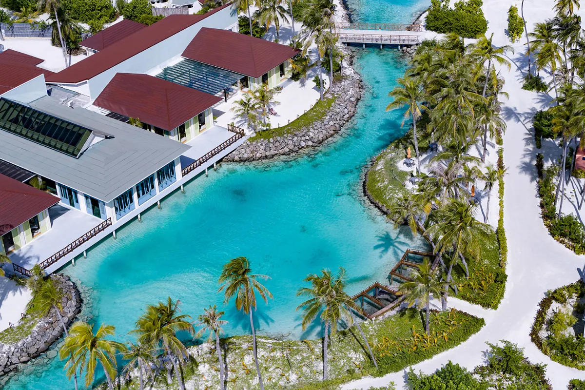 Oblu Xperience Ailafushi — вид на зеленую лагуну и постройки отеля