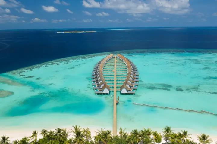 Outrigger Maldives Maafushivaru Resort — панорамный вид на остров с водными виллами
