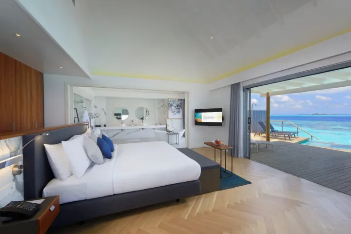 Outrigger Maldives Maafushivaru Resort — просторная спальня с панорамными окнами