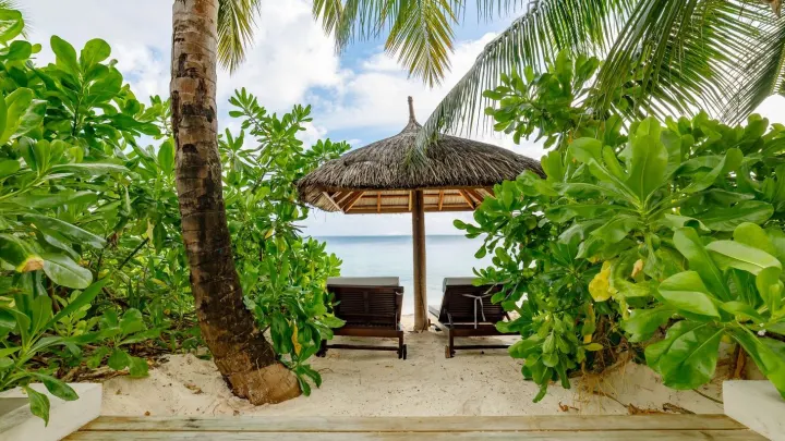 OZEN Reserve Bolifushi — песчаный пляж с зонтиками и шезлонгами