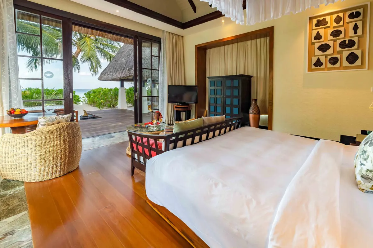 OZEN Reserve Bolifushi — интерьер спальни с панорамными окнами на пляж