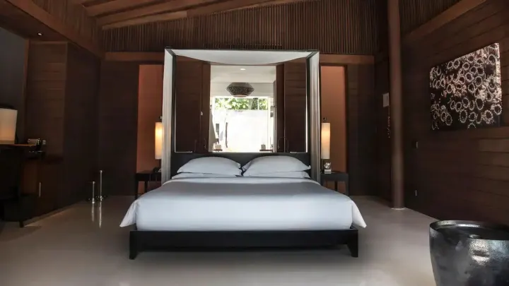 Park Hyatt Maldives Hadahaa — спальня виллы с отделкой из натурального дерева и видом на сад