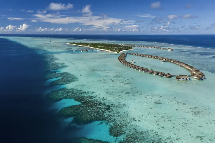 Pullman Maldives Maamutaa — вид сверху на зеленый остров и риф