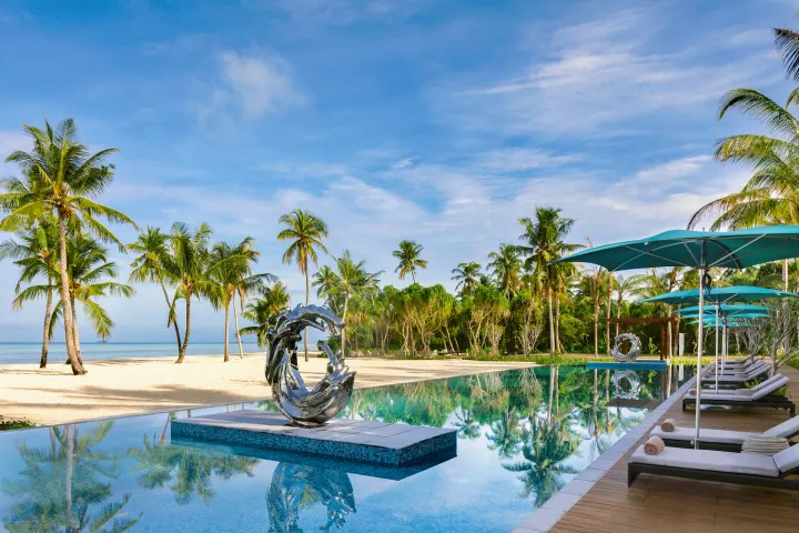 Pullman Maldives Maamutaa — инфинити-бассейн с шезлонгами у пляжа