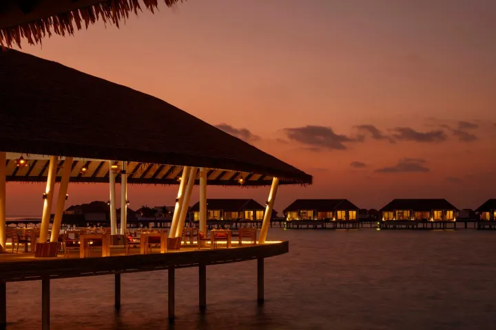 Radisson Blu Resort Maldives — ресторан над водой на закате