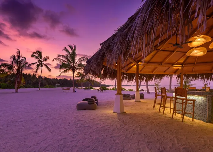 Rahaa Resort, Мальдивы — бар Rahaa Resort — пляжный бар среди кокосовых пальм в лучах заката