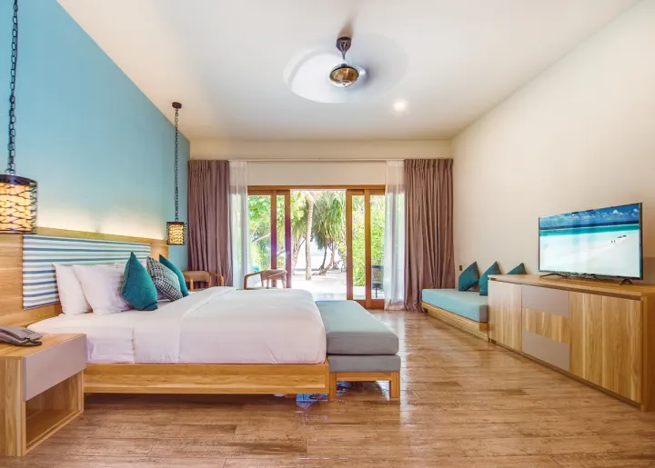 Rahaa Resort, Мальдивы — интерьер виллы Rahaa Resort — светлая спальня береговой виллы с выходом на террасу и пляж