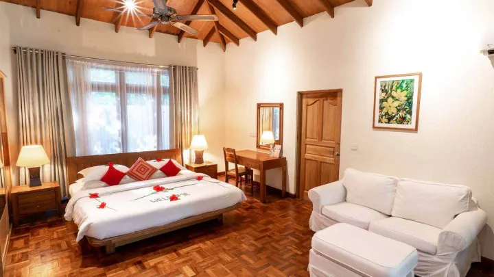 Reethi Faru Resort, Мальдивы — интерьер виллы Reethi Faru Resort — просторная спальня с широкой кроватью