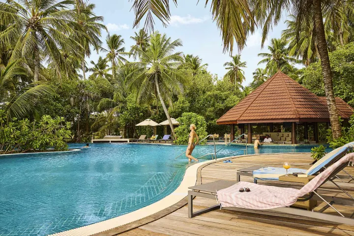 Robinson Club Maldives — просторный бассейн в окружении тропических пальм