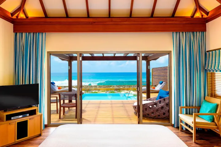 Sheraton Maldives Full Moon Resort & Spa, Мальдивы — интерьер виллы Sheraton Maldives Full Moon Resort & Spa — светлая спальня виллы с панорамным видом на океан