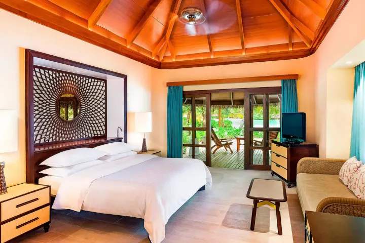 Sheraton Maldives Full Moon Resort & Spa, Мальдивы — интерьер виллы Sheraton Maldives Full Moon Resort & Spa — спальня с деревянным потолком и террасой