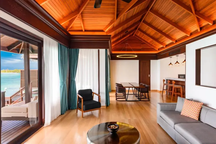 Sheraton Maldives Full Moon Resort & Spa, Мальдивы — интерьер виллы Sheraton Maldives Full Moon Resort & Spa — просторная гостиная с диваном и обеденной зоной