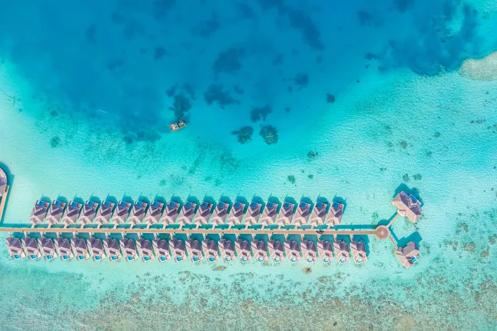 Sun Siyam Iru Veli — вид сверху на лазурную лагуну и виллы на воде