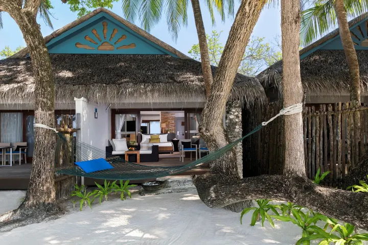 Taj Coral Reef Resort & Spa — пляжная вилла с гамаком среди зеленых пальм