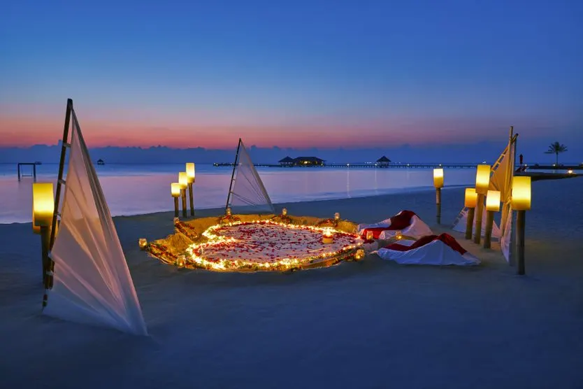 Taj Exotica Resort & Spa — романтическая композиция со свечами на вечернем пляже