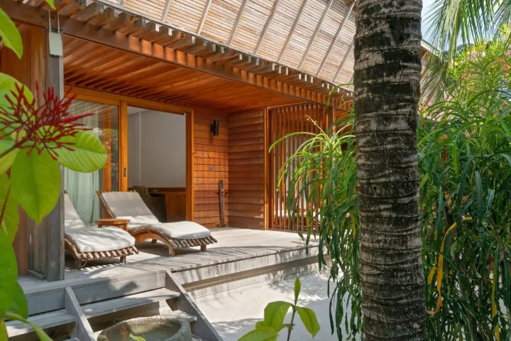 The Barefoot Eco Hotel, Мальдивы — вилла на пляже The Barefoot Eco Hotel — деревянная терраса берегового номера с шезлонгами и прямым выходом к океану