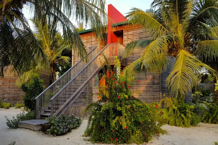 The Barefoot Eco Hotel, Мальдивы — интерьер виллы The Barefoot Eco Hotel — светлая спальня номера на верхнем этаже с балконом и видом на лагуну