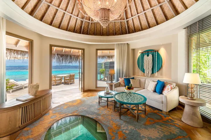 The Nautilus Maldives — светлая гостиная водной виллы с панорамным видом на океан