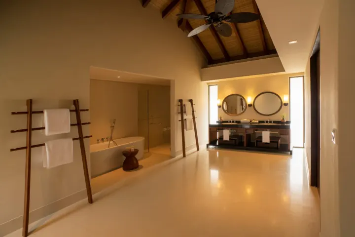 The Residence Maldives at Dhigurah — светлая ванная комната с отдельно стоящей ванной и видом на океан