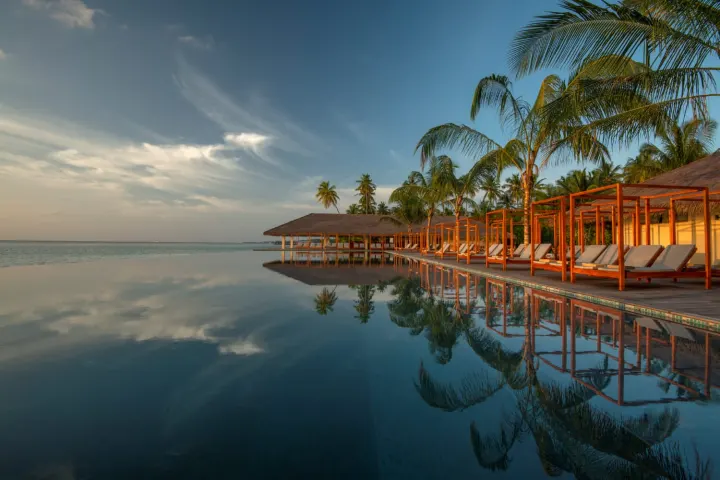 The Residence Maldives at Dhigurah — главный инфинити-бассейн пляжного клуба у кромки воды