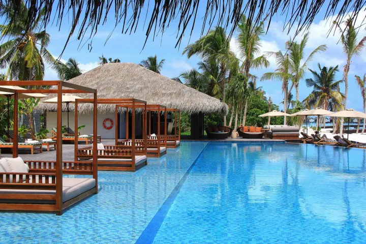 The Residence Maldives at Falhumaafushi — главный панорамный бассейн у пляжа с шезлонгами и видом на лагуну