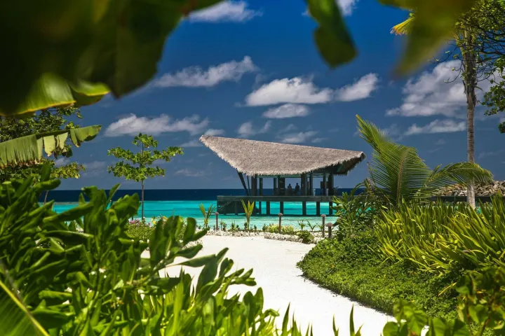 The Residence Maldives at Falhumaafushi — просторная спальня виллы в колониальном стиле с кроватью под балдахином