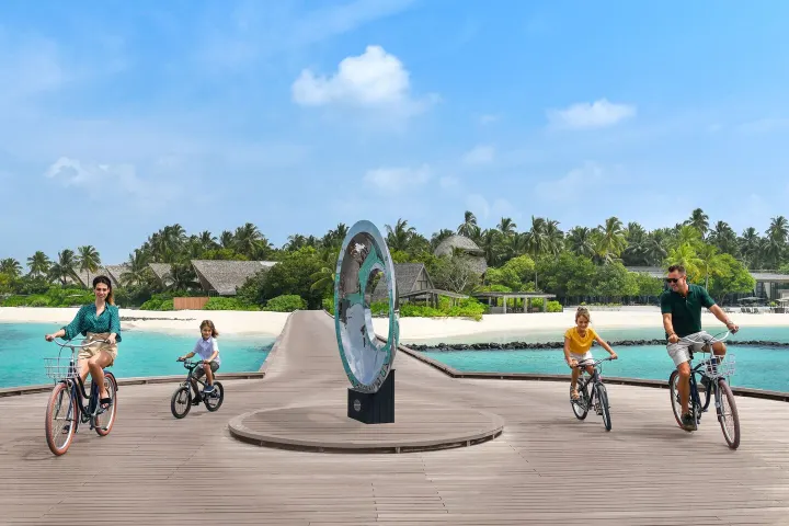 The St. Regis Maldives Vommuli Resort, Мальдивы — для детей The St. Regis Maldives Vommuli Resort — дети катаются на велосипедах по деревянным дорожкам